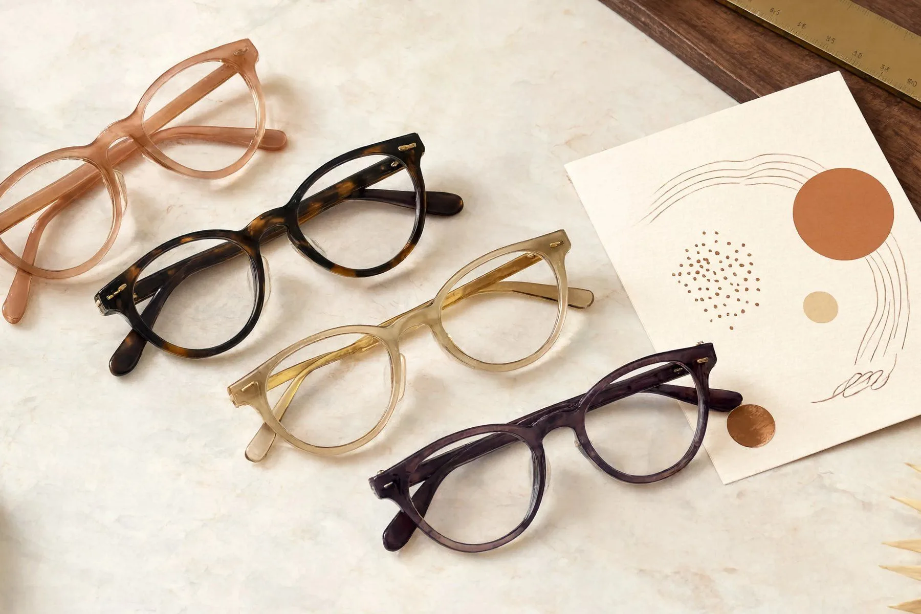 Reframe, eyewear frames on a marble counter beside a scored recommendation card